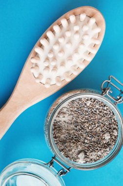 Kendi vücut masajı ve mavi arka planda tuz ve lavanta ile ev yapımı fırçalama için ahşap fırça. Selülit tedavisi. Spa ve vücut bakımı