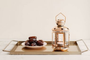 Altın renkli fener ve kurutulmuş hurma kısmı ile Tepsi. Ortadoğu'da Ramazan ayı