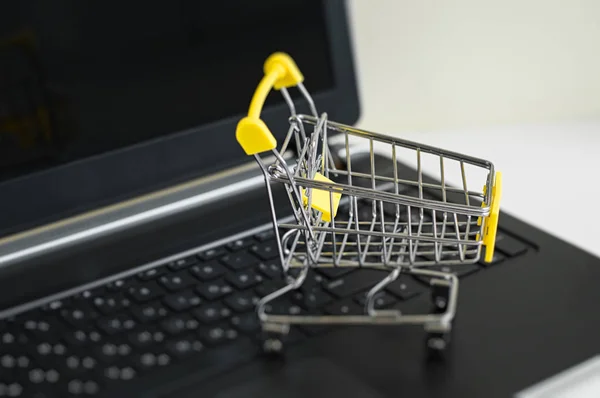 Small shopping trolley toy and black computer keyboard. Online shopping. Internet shopping. E-commerce. Cyber monday