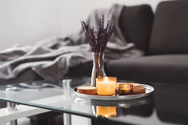 咖啡桌设计理念 香气蜡烛和干薰衣草花束放在金属托盘上 沙发背景为灰色毛毯 简单的丑闻家居装饰 Hygge概念 — 图库照片