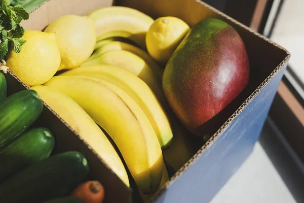 Mango Fresco Plátano Limón Hierbas Zanahoria Pepinos Una Caja Papel — Foto de Stock