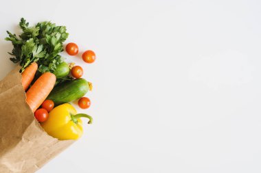 Beyaz arka planda çevre dostu kağıt torbalarda taze sebzeler ve otlar. Yemek servisi. Market alışverişi