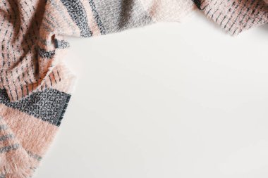 Beyaz arka planda pembe ve gri renkli yün atkı, üst manzara, kopyalama alanı. Sonbahar ya da kış mevsimi