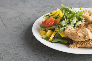 Taze sebze salatası, pişmiş hindi göğsü ve kepekli makarna. Sağlıklı ve dengeli yemek.