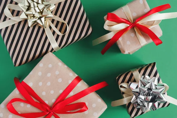 礼品盒 用手工纸包好 红色和黄色缎带 绿色背景 顶视图 圣诞礼物 — 图库照片