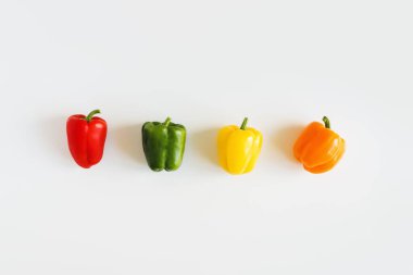 Kırmızı, yeşil, sarı ve turuncu dolmalık biber beyaz arka planda, üst manzara. Düz yat. Capsicum karışımı