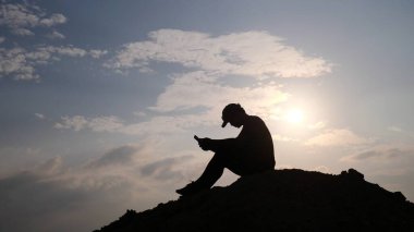man with backpack and smartphone in the mountains