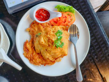 Taze sebze ve baharatlı sosla servis edilen lezzetli bir Tayland omleti. Lezzetli bir yemek için mükemmel..