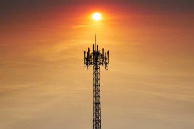 Güzel günbatımı arkaplanlı cep telefonu anteni.