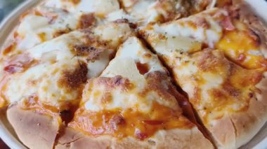 Beyaz tabakta peynirli ve domates soslu pizza