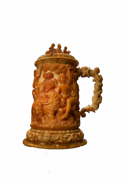 This carved mug displays intricate scenes of celebration, crafted from a warm material. The detailed figures highlight skilled artistry and cultural themes, making it a valuable piece.