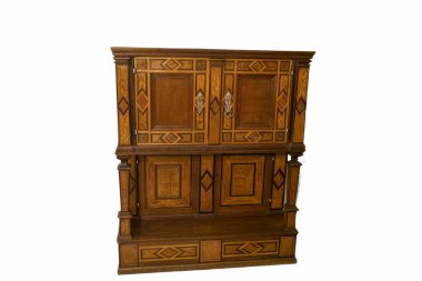 Detaylı oymalar ve tasarımlarla dolu güzel ahşap dolap parlak bir odada ustalıklı işçiliği ve klasik estetiği ön plana çıkarıyor. Ev dekoratörü ya da koleksiyoncular için ideal.