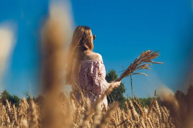 Buğday içeren alanı üzerinde yürüyen kız