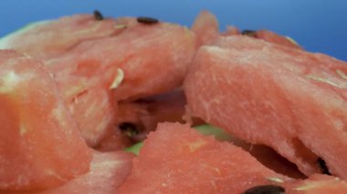 Tabakta karpuz parçaları var. Yakın çekim, makro çekim. Kamera sorunsuz hareket ediyor.