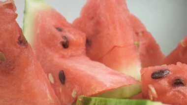 Tabakta karpuz parçaları var. Yakın çekim, makro çekim. Kamera sorunsuz hareket ediyor.