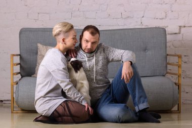 Güzel genç aile köpek ile katta oturur