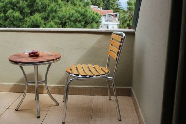 Balkondan görüntüleyin. Bir sandalye ve masa yakın caddeye bakan balkon. Eğlence için yer