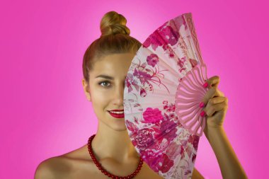 Parlak makyaj ve eller yakın çekim pembe arka plan üzerinde renkli fan ile güzel bir genç kız portresi. Geyşa cosplay.