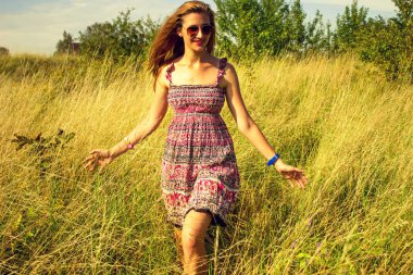 Genç güzel kız aracılığıyla yüksek kuru çim alan ve ishal elinde yaz aylarında yürüyüş.
