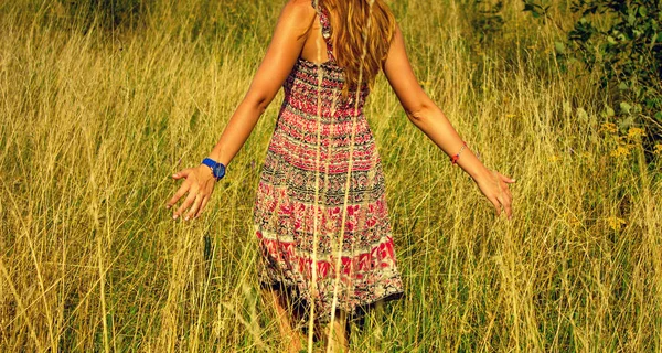 Genç güzel kız aracılığıyla yüksek kuru çim alan ve ishal elinde yaz aylarında yürüyüş.