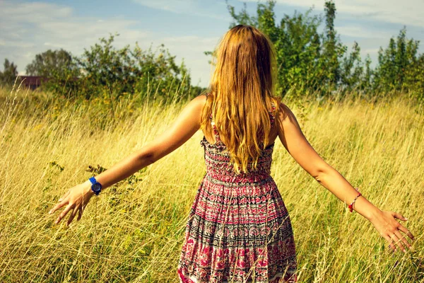 Genç güzel kız aracılığıyla yüksek kuru çim alan ve ishal elinde yaz aylarında yürüyüş.