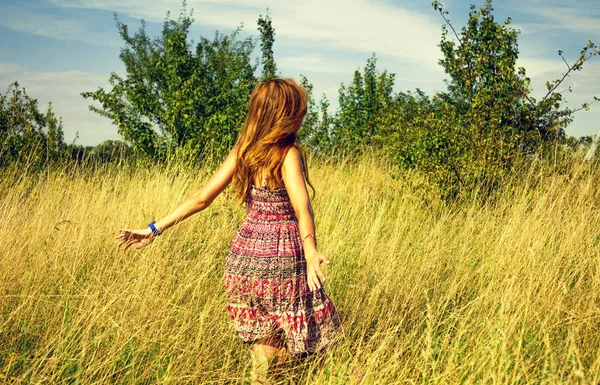 夏に高乾燥草をフィールドと実行手に歩いて美しい少女 — ストック写真