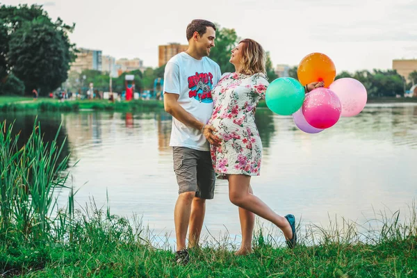 Pasangan yang indah jatuh cinta pada latar belakang danau di taman di penutupan musim panas — Stok Foto
