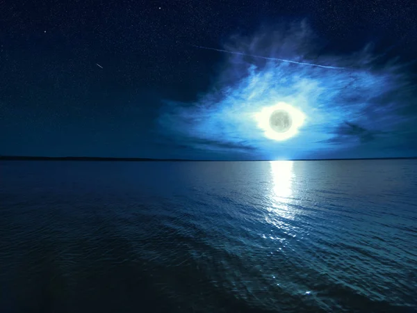 Hermoso cielo estrellado de noche azul mágico con nubes y luna llena con reflejo de luz de luna en el agua — Foto de Stock