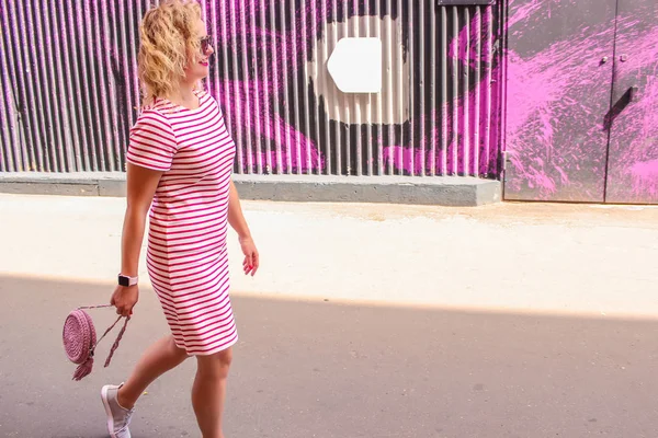 Jovem menina bonita e elegante está andando ao longo da rua no horário de verão — Fotografia de Stock