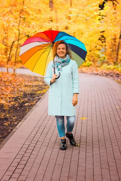 年轻美丽的女孩走在秋季公园与五颜六色的雨伞 — 图库照片