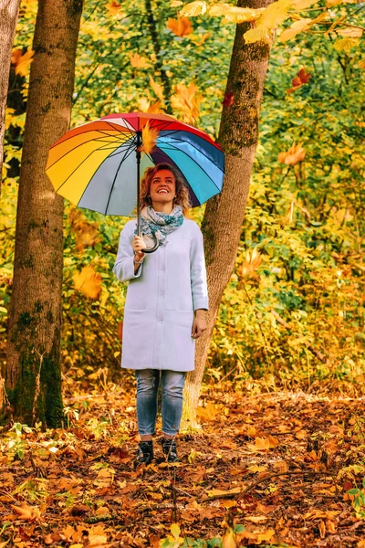 年轻美丽的女孩走在秋季公园与五颜六色的雨伞 — 图库照片