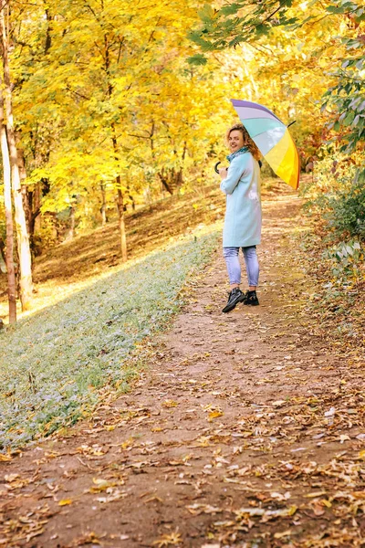 年轻美丽的女孩走在秋季公园与五颜六色的雨伞 — 图库照片