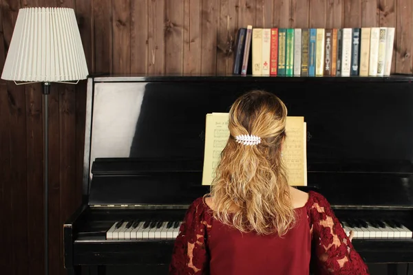 Молода красива жінка грає на чорному піаніно крупним планом — стокове фото