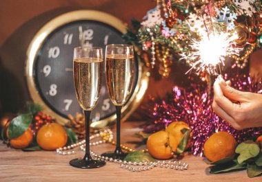 Saat, oluşan Noel kompozisyon hangi saat 12 yönünde, bardak şampanya kabarcıklar ile bir kızın elinde havai fişekleri oktur.