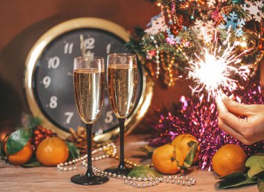 Saat, oluşan Noel kompozisyon hangi saat 12 yönünde, bardak şampanya kabarcıklar ile bir kızın elinde havai fişekleri oktur.