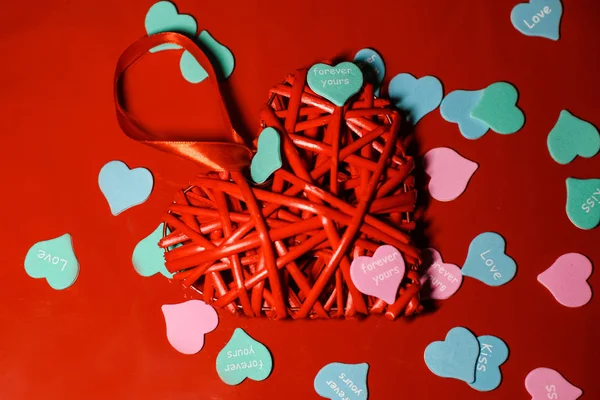 Beautiful red heart closeup with decorations from multi-colored hearts.