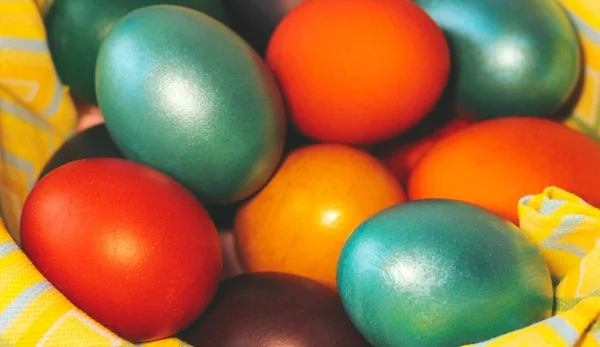 Multicolored painted eggs in the basket close up.