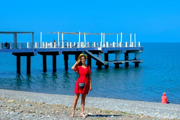 Joven chica atractiva en un vestido rojo cerca del mar en el verano, Batumi, Georgia — Foto de Stock