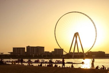Dubai Marina alanında gün batımı sırasında Kumlu plaj.