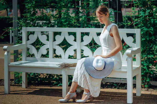 Giovane bella donna in abito bianco nel giardino verde con fiori da vicino in estate — Foto Stock