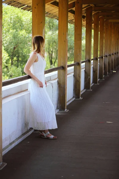 Jong mooi meisje in een witte jurk close-up op het aquaduct brug achtergrond — Stockfoto