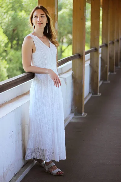 Jong mooi meisje in een witte jurk close-up op het aquaduct brug achtergrond — Stockfoto