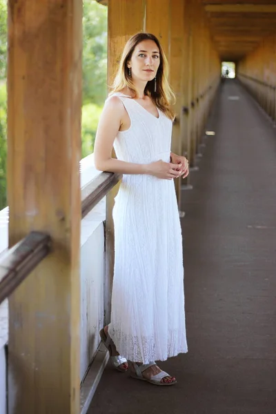 Jong mooi meisje in een witte jurk close-up op het aquaduct brug achtergrond — Stockfoto