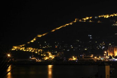 Parıldayan dağ ve Kızıl Kale ile gece kenti Alanya manzarası
