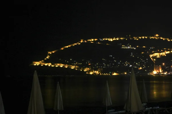 輝く山と赤い城キジル・クレの夜市アルアンヤの眺め — ストック写真