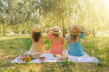Yaz mevsiminde parkta piknikte üç güzel kadın..