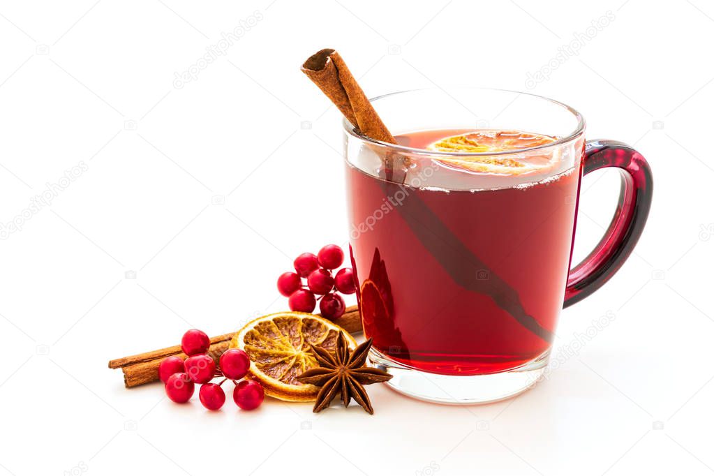 Hot red mulled wine isolated on white background with christmas spices, orange slice, anise and cinnamon sticks.