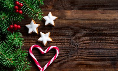 Noel tarçınlı bisküvi yıldız şeklinde, şekerler ve köknar dalı eski ahşap tahta üzerinde arka plan. Kopya alanı