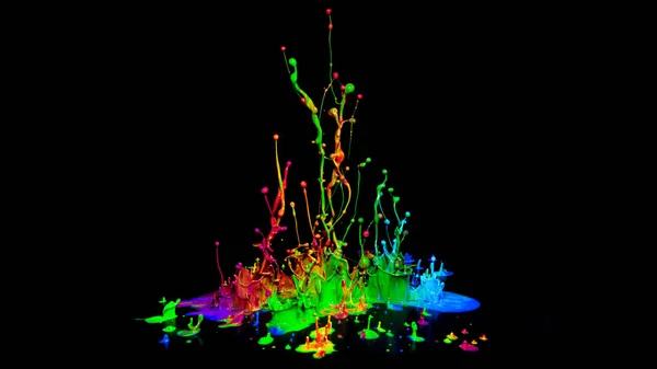 Colorful paint splashing on audio speaker isolated on black background