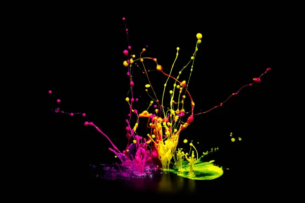 Colorful paint splashing on audio speaker isolated on black background